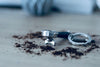 Barista Siebträger-Schlüsselanhänger mit Schlüsselring, Vorderansicht zwischen Kaffeepulver