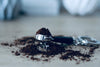 Barista Siebträger-Schlüsselanhänger, mit Kaffeepulver gefüllt auf Holztisch
