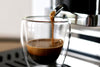 Arabi Caffe E.S.E.-Pads: Nahaufnahme des Espressostrahls in ein Glas mit Crema