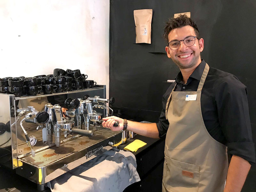 Antonino mit Schürze an Siebträgermaschine